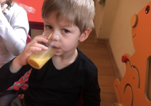 Mikołaj pije soczek pomarańczowy.
