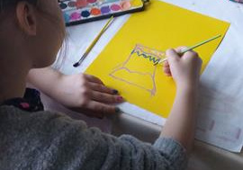 Kaja wykonuje pracę plastyczną.