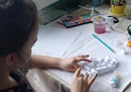 Nadia wykonuje pracę plastyczną.