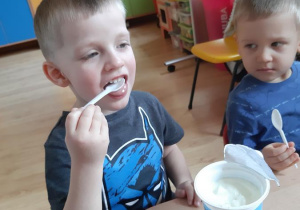 Adaś próbuje jogurt naturalny.