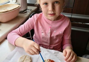 Hania maluje wykonane pieczywo z masy solnej.