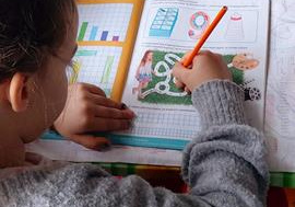 Nadia wykonuje ćwiczenia w kartach pracy.