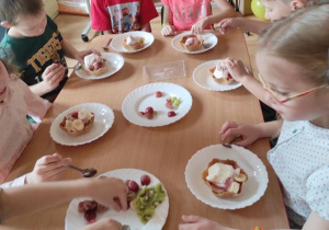 Dzieci wykonują deser lodowo- owocowy.