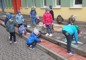 Dzieci z grupy Motylki podczas malowania kredą.