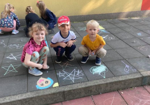 Dzieci tworzą obrazki na przedszkolnym tarasie.