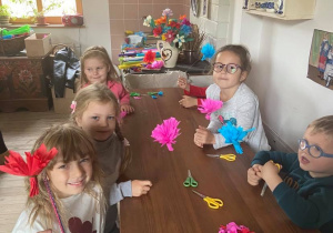 Dzieci robią kwiaty z bibuły.