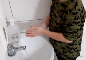 Jacek w łazience myje ręce.