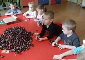 Adam, Nikola, Zosia, Adam i Kuba podczas pracy nad ludzikami z kasztanów.