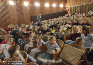 Dzieci w teatrze oglądają przedstawienie.