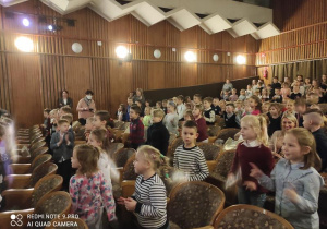 Dzieci w teatrze oglądają przedstawienie.