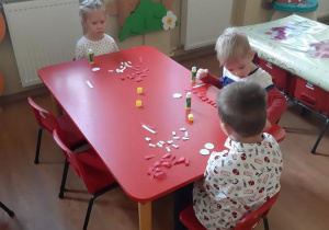 Nikola, Tymon i Mateusz w trakcie robienia kotylionów.