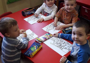 Witek, Antek, Kuba i Miłosz malują kolorowankę andrzejkową.