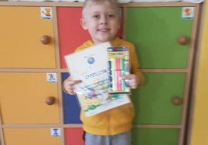 Dominik z dyplomem i nagrodą za udział w konkursie.