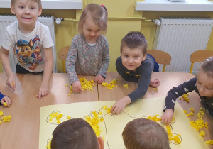 Jacek, Lena i Kuba wyklejają Kubusia Puchatka.