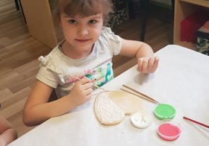 Magda ozdabia słodki upominek dla babci i dziadka.