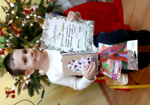 Tymek ze swoim konkursowym pudełkiem i dyplomem.