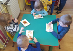 Dzieci zjadają pizzę ze smakiem.