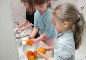 dziewczynki myją pomarańcze na sok