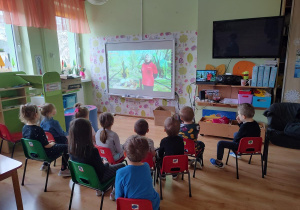 Dzieci oglądają film edukacyjny o dinozaurach