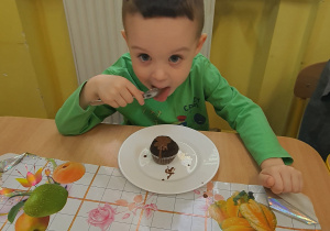 Filip pokrywa czekoladą swoją muffinkę.