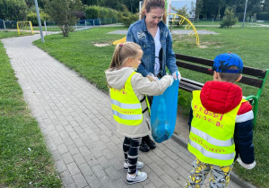 Tosia wrzuca śmieci do worka.