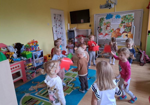 Dzieci tańczą z liśćmi.