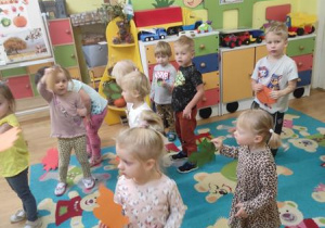 Dzieci tańczą z listkami do piosenki.