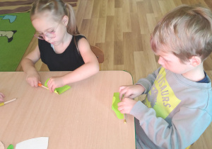Hania Z. i Jacek zawijają liście sałaty z papieru