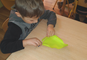 chłopiec zawija liście sałaty z papieru