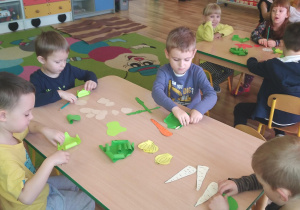 dzieci zawijają liście sałaty z papieru