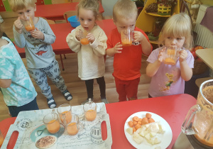 Dzieci piją koktajl owocowo-warzywny.