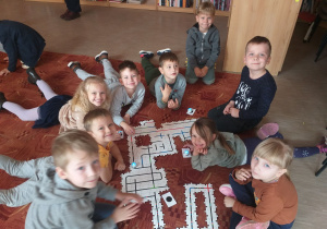 Dzieci z grupy Żabki podczas wspólnego budowania trasy dla ozobotów.
