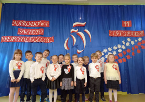 Grupa dzieci na tle dekoracji z okazji Święta Niepodległości