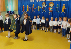 Dzieci z grupy sześciolatków ,,Kreciki" dumnie prezentują proporzec przedszkola.