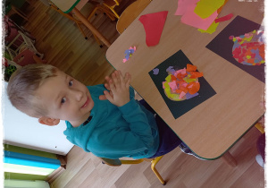 Jacek wykleja bombkę kawałkami kolorowego papieru