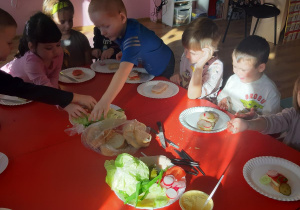Dzieci dobierają składniki kanapek według własnego uznania.