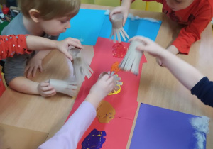 Dzieci maczają rolkę w farbie