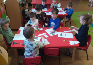 Dzieci układają bałwanka i przyklejają na kartkę