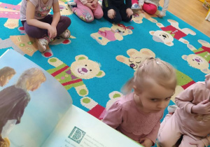 Dzieci słuchają bajki czytanej przez nauczycielkę