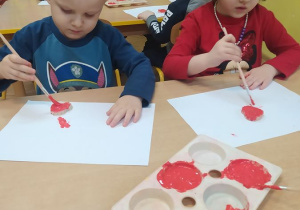 Oluś i Lila malują farbami serduszko z masy solnej
