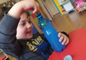 Maks barwi wodę w butelce sensorycznej