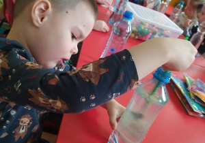 Oskar barwi wodę w butelce sensorycznej