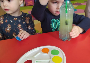 Roman barwi wodę w butelce sensorycznej