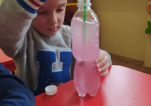 Sławek barwi wodę w butelce sensorycznej