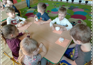 grupa dzieci zjada pączki