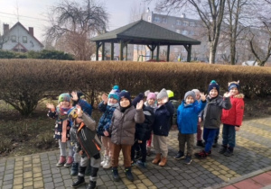 Dzieci spacerują po terenie ogrodu i placu przedszkolnego.