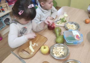 Dzieci przygotowują sałatkę.
