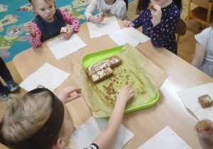 Dzieci zajadają ciasto marchewkowe.