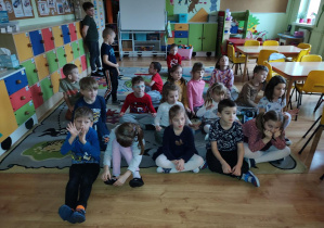 Dzieci oglądają film instruktażowy, pokazujący sposoby gry na bębnie