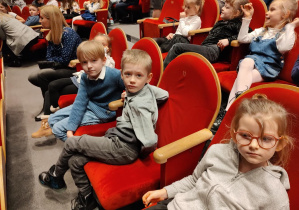 Dzieic siedzą w teatrze podczas przerwy w spektaklu